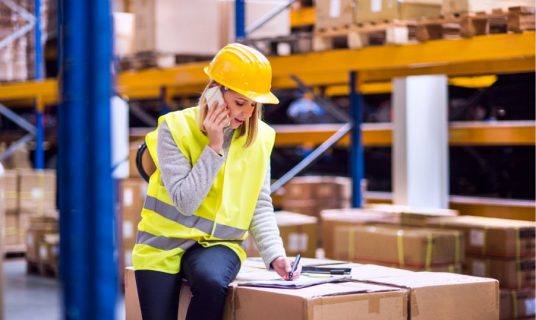 woman-warehouse-worker-with-smartphone-PYVQVFL-min (1)